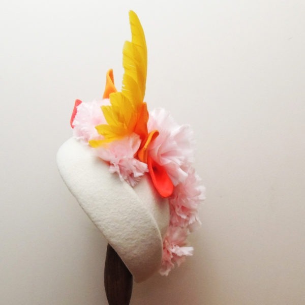 Petit chapeau de cérémonie rétro en feutre ivoire. Style vintage avec fleurs roses et feuilles oranges en tissu, et plumes jaunes. Oh... Really? par Sandra Lacroix, chapelière, Bruxelles.