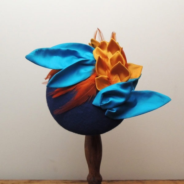 Chapeau de cérémonie rétro en feutre bleu royal. Style vintage avec plumes et décorations en tissu bleu, orange et jaune moutarde. Oh... Really? par Sandra Lacroix, chapelière, Bruxelles.