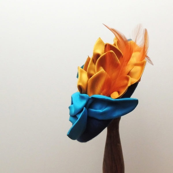 Chapeau de cérémonie rétro en feutre bleu royal. Style vintage avec plumes et décorations en tissu bleu, orange et jaune moutarde. Oh... Really? par Sandra Lacroix, chapelière, Bruxelles.