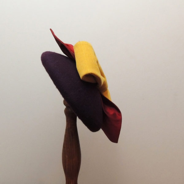 Bibi rond en feutre violet rétro et de style vintage, avec nœud jaune et feuilles rouges en tissu. Oh... Really? par Sandra Lacroix, chapelière, Bruxelles.