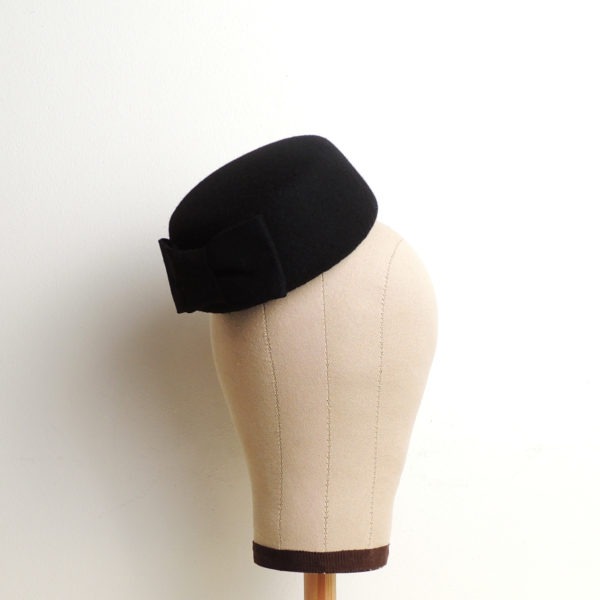 Petit chapeau rétro rond en feutre noir. Fez de style vintage avec nœud. Oh... Really? par Sandra Lacroix, chapelière, Bruxelles.